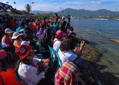 Warga menyaksikan Kejuaraan Dunia Perahu Motor F1 PowerBoat (F1H2O) di pinggir Danau Toba, Balige, Sumatera Utara, Minggu (26/2/2023).