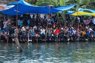 Warga menyaksikan Kejuaraan Dunia Perahu Motor F1 PowerBoat (F1H2O) di pinggir Danau Toba, Balige, Sumatera Utara, Minggu (26/2/2023).