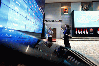 Karyawan berdiri di dekat layar pergerakan Indeks Harga Saham Gabungan (IHSG) di Bursa Efek Indonesia, Jakarta, Selasa (28/2/2022).