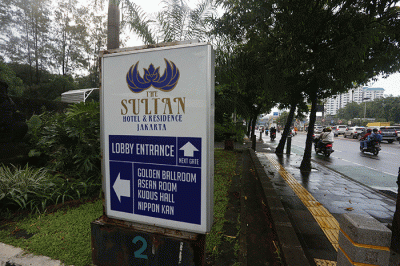 Warga melintas di depan Hotel Sultan, kawasan Gelora Bung Karno, Senayan, Jakarta, Jumat (3/3/2023).