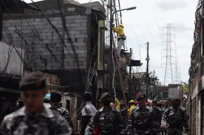 Petugas Suku Dinas Bina Marga Jakarta Utara memperbaiki fasilitas lampu penerangan jalan di permukiman penduduk yang hangus terbakar.