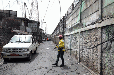 Petugas Suku Dinas Bina Marga Jakarta Utara memperbaiki fasilitas lampu penerangan jalan di permukiman penduduk yang hangus terbakar.