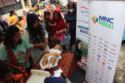 Head of CSR MNC Group Tengku Havid (kiri) memberikan secara simbolik bantuan kepada salah satu pengurus RW di Petojo Utara, Jakarta, Selasa (14/3/2023).