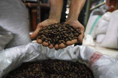Pedagang memasukan kopi kedalam kemasan di Dunia Kopi, Pasar Santa, Jakarta, Kamis (16/3/2023).