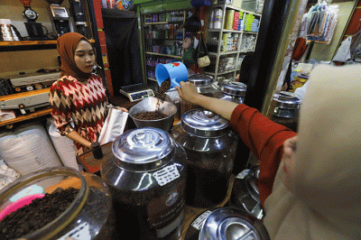Pedagang memasukan kopi kedalam kemasan di Dunia Kopi, Pasar Santa, Jakarta, Kamis (16/3/2023).