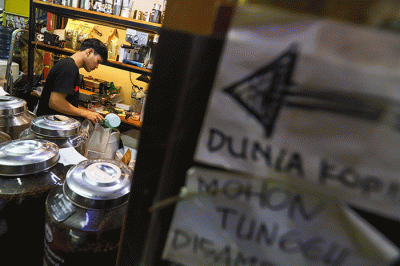 Pedagang memasukan kopi kedalam kemasan di Dunia Kopi, Pasar Santa, Jakarta, Kamis (16/3/2023).