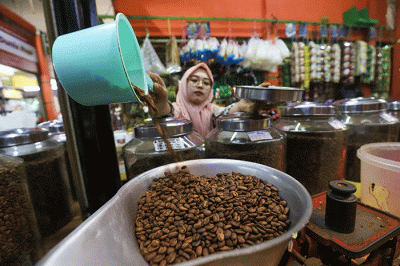 Pedagang memasukan kopi kedalam kemasan di Dunia Kopi, Pasar Santa, Jakarta, Kamis (16/3/2023).