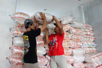 Warga menerima bantuan beras seberat 10 kg di kawasan Serdang Kemayoran, Jakarta, Sabtu (18/3/2023).