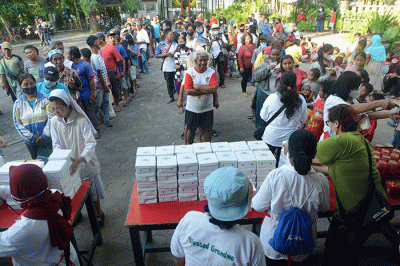 Ratusan warga mengantre untuk mendapatkan paket makanan untuk berbuka puasa yang dibagikan Tim Pelayanan Aksi Piring Kasih di Gereja Santa Theresia.