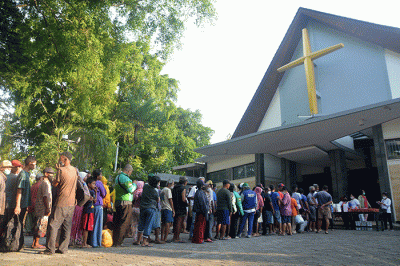 Ratusan warga mengantre untuk mendapatkan paket makanan untuk berbuka puasa yang dibagikan Tim Pelayanan Aksi Piring Kasih di Gereja Santa Theresia.
