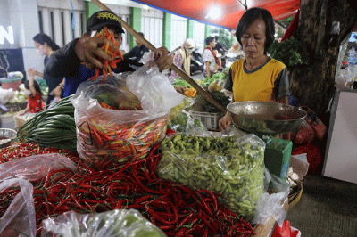 Pedagang melayani pembeli di kawasan pasar tradisional Kemayoran, Jakarta, Sabtu (25/3/2023).