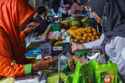 Warga Membayar belanjaan di Pasar Ramadan Digital dengan QRIS di halaman Kantor Camat Ilir Timur I Palembang, Rabu (29/3/2023).