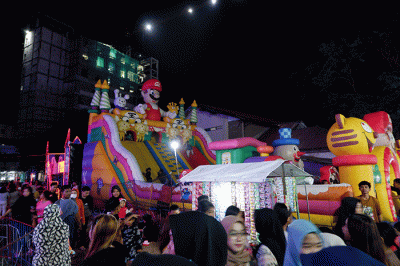 Sejumlah pengunjung menikmati suasana di wahana bermain Pasar Malam Masjid Markaz Al Islami, Makassar, Kamis (30/3/2023).
