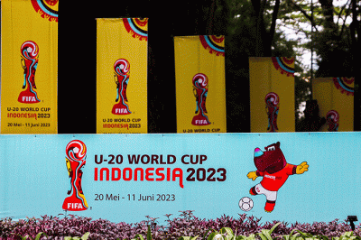 Warga melintas di dekat papan promosi Piala Dunia U-20 Indonesia 2023 di kawasan GBK, Senayan, Minggu (2/3/2023).