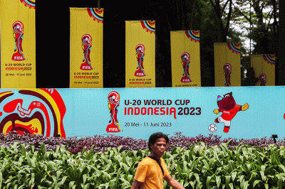 Warga melintas di dekat papan promosi Piala Dunia U-20 Indonesia 2023 di kawasan GBK, Senayan, Minggu (2/3/2023).