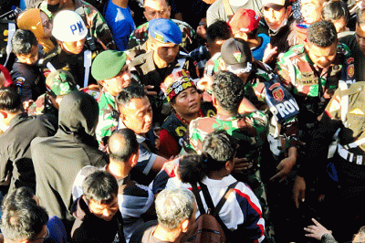 Ida Dayak (tengah) dijaga provos dalam kerumunan warga yang meminta pengobatannya di Lapangan Kostrad Cilodong, Depok, Jawa Barat, Senin (3/4/2023).