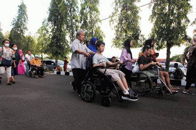 Ida Dayak (tengah) dijaga provos dalam kerumunan warga yang meminta pengobatannya di Lapangan Kostrad Cilodong, Depok, Jawa Barat, Senin (3/4/2023).