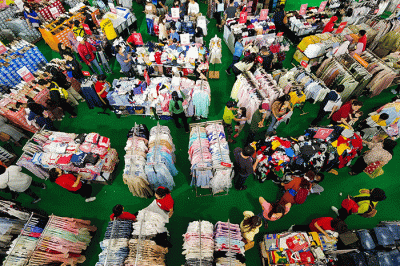 Pengunjung saat memilih pakaian yang dijual diskon di Pusat Perbelanjaan, Jakarta, Minggu (2/4/2023).