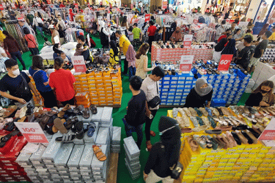 Pengunjung saat memilih pakaian yang dijual diskon di Pusat Perbelanjaan, Jakarta, Minggu (2/4/2023).