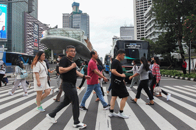Pekerja melintas saat jam pulang kerja di kawasan Sudirman-Thamrin, Jakarta, Selasa (4/4/2023).
