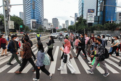Pekerja melintas saat jam pulang kerja di kawasan Sudirman-Thamrin, Jakarta, Selasa (4/4/2023).