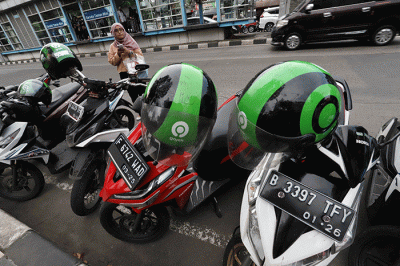 Mitra pengemudi Gojek sedang menunggu penumpang di kawasan Taman Mini Indonesia Indah (TMII), Jakarta Timur, Jumat (7/4/2023).