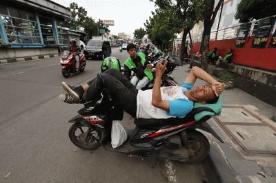 Mitra pengemudi Gojek sedang menunggu penumpang di kawasan Taman Mini Indonesia Indah (TMII), Jakarta Timur, Jumat (7/4/2023).