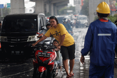 Sejumlah kendaraan bermotor menerobos banjir di Jalan AP Pettarani, Makassar, Senin (10/4/2023).
