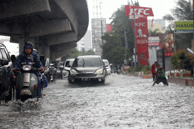 Sejumlah kendaraan bermotor menerobos banjir di Jalan AP Pettarani, Makassar, Senin (10/4/2023).