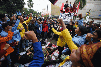 Mahasiswa melakukan aksi teaterikal saat demo menolak pengesahan Undang Undang Cipta Kerja di kantor DPRD Sumsel, Rabu (12/4/2023).