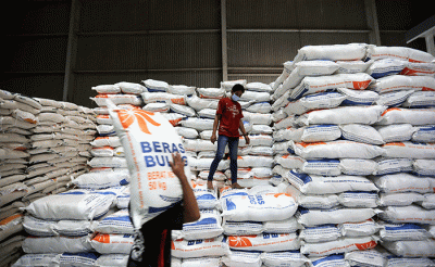 Petugas mengemas beras di gudang Bulog, Jakarta, Jumat (14/4/2023).