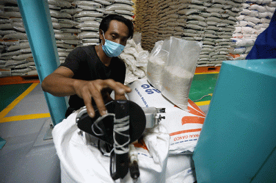 Petugas mengemas beras di gudang Bulog, Jakarta, Jumat (14/4/2023).