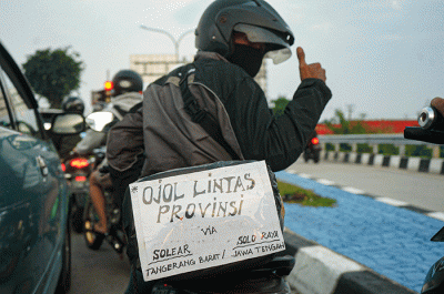 Pemudik menggunakan sepeda motor melintas di Jalan M Hasibuan, Bekasi, Jawa Barat, Selasa (18/4/2023).