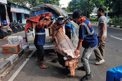 Pekerja tengah mengepak sepeda motor yang akan di kirim melalui jasa pengiriman dengan kereta api di Kawasan Stasiun Senen, Jakarta, Senin (17/4/2023).