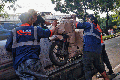 Pekerja tengah mengepak sepeda motor yang akan di kirim melalui jasa pengiriman dengan kereta api di Kawasan Stasiun Senen, Jakarta, Senin (17/4/2023).