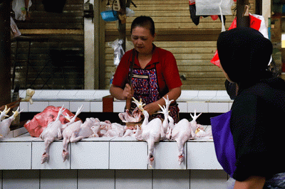 Pedagang ayam potong saat menunggu pembeli di pasar tradisional di kawasan Jakarta Selatan, Senin (17/4/2023).