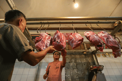 Pedagang daging sapi melayani pembeli di pasar tradisional di kawasan Jakarta Selatan, Senin (17/4/2023).