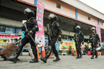Sejumlah anggota Brimob bersenjata saat berpatroli di Terminal Kampung Rambutan, Jakarta Timur, Rabu (19/4/2023).