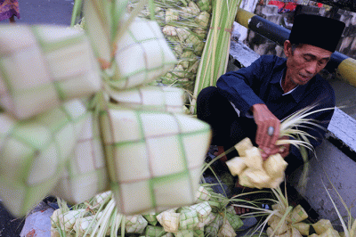Pedagang kulit ketupat melayani pembeli di kawasan Pasar Tradisional Serdang, Jakarta, Rabu (19/4/2023).