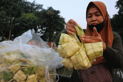 Pedagang kulit ketupat melayani pembeli di kawasan Pasar Tradisional Serdang, Jakarta, Rabu (19/4/2023).