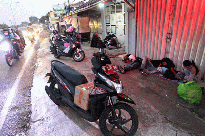 Pemudik roda dua dengan tujuan Jawa Tengah saat beristirahat di jalur Pantura, Kabupaten Karawang, Jawa Barat, Rabu (19/4/2023).