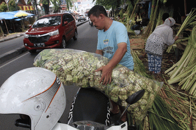 Pedagang kulit ketupat membuat ketupat di kawasan Palmerah, Jakarta, Jumat (21/4/2023).