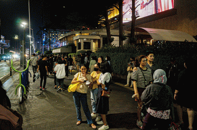 Sejumlah warga berswafoto di kawasan Bundaran HI, Jakarta, Minggu (23/4/2023).