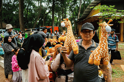Hendra (66) salah satu penjual boneka hewan menunjukkan dagangannya di Taman Margasatwa Ragunan, Senin (24/4/2023).