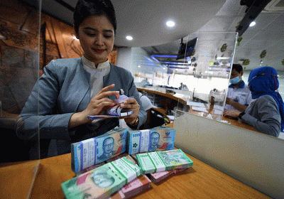 Teller Bank BTN sedang menghitung uang pecahan baru untuk melayani kebutuhan nasabah di Kantor Cabang Bank BTN Harmoni, Jakarta, Rabu (26/4/2023).