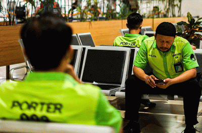 Porter saat membantu pemudik membawa barang di Stasiun Pasar Senen, Jakarta, Rabu (26/4/2023).