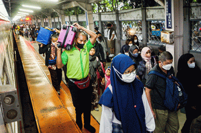 Porter saat membantu pemudik membawa barang di Stasiun Pasar Senen, Jakarta, Rabu (26/4/2023).