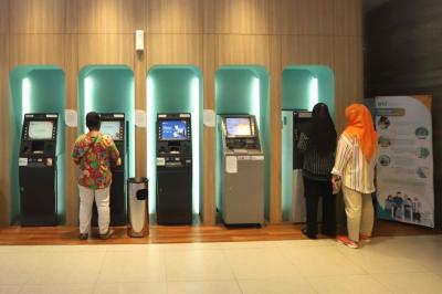 Nasabah melakukan transaksi di mesin anjungan tunai mandiri (ATM) di Gedung Wisma Mandiri I di Jakarta.