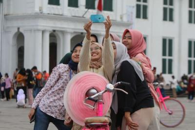 Pengunjung berswafoto di halaman Museum Fatahillah kawasan Kota Tua Jakarta.