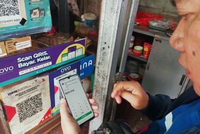 Pembeli menggunakan fitur QRIS di salah satu warung makanan di kawasan Persada Kuningan Raya, Jakarta, Sabtu (27/5/2023).